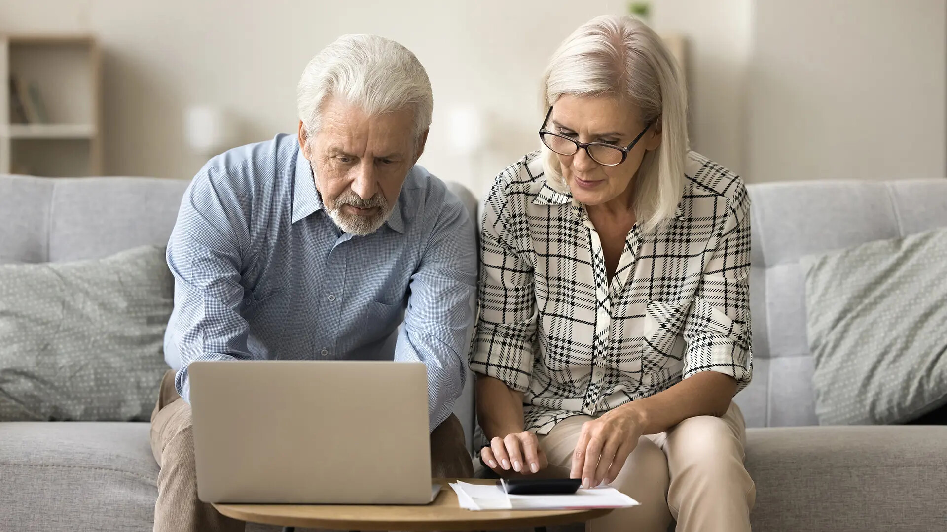 Immobilieneigentümer-Ehepaar arbeitet am Laptop