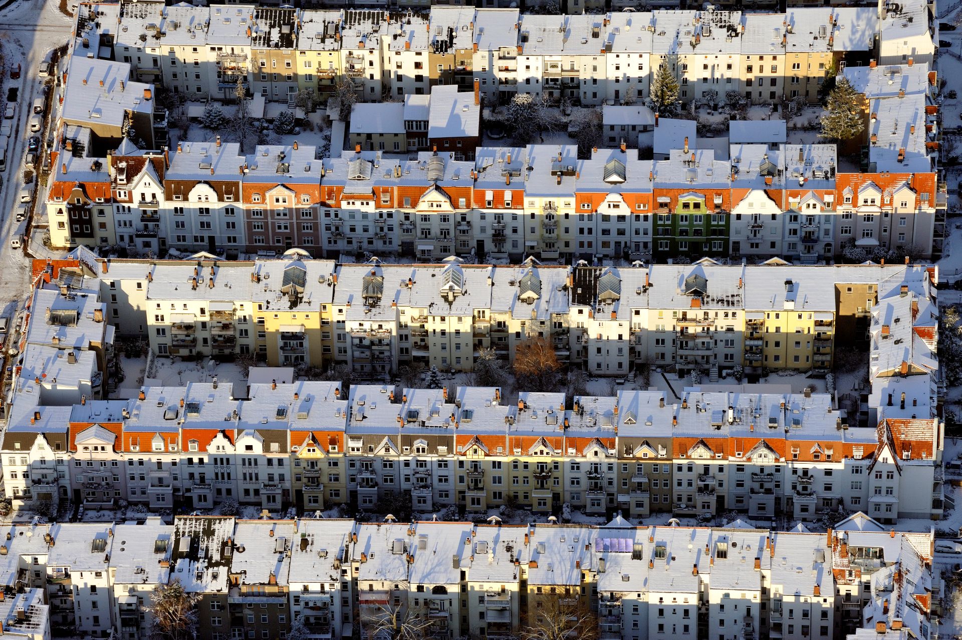 Schneebedeckte Wohnblocks in Reihen in einer Stadt von oben.
