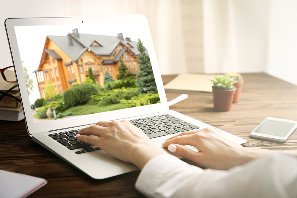Eine Frau schaut sich eine Immobilie am Laptop an
