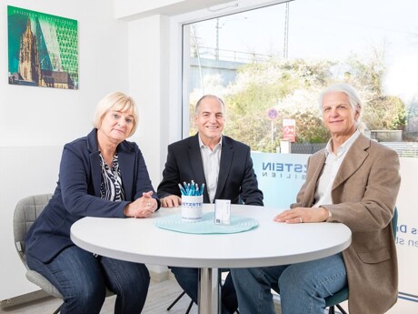 Das Team von Wetzstein Immobilien sitzt zusammen am Tisch im Büro