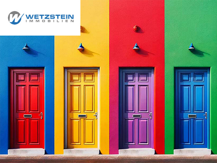 Vier bunte Haustüren in Rot, Gelb, Blau und Grün nebeneinander an einer farbigen Wand