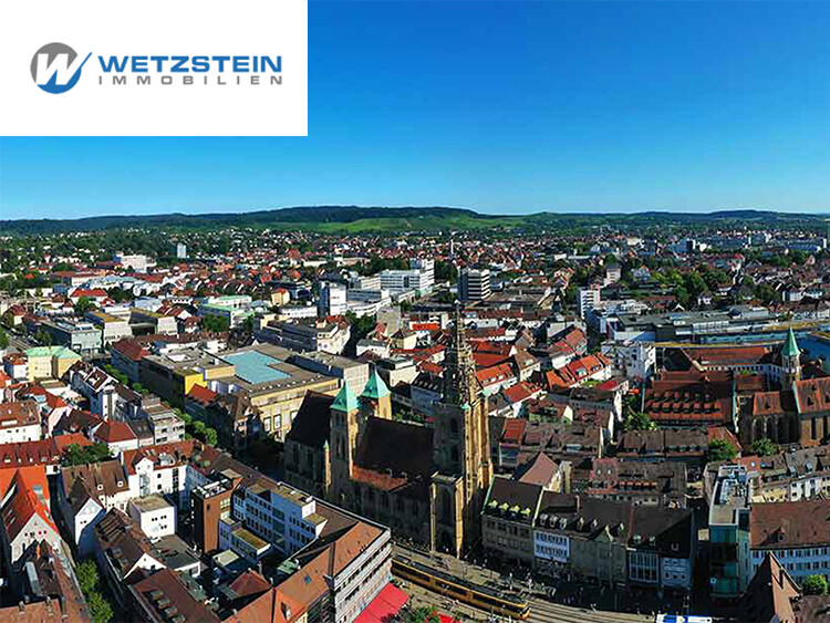 Luftaufnahme der Stadt Freiburg im Breisgau mit Blick auf das Münster und umliegende Gebäude bei klarem Himmel