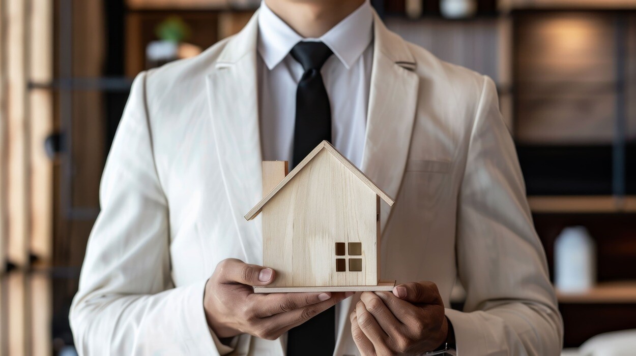 Makler hält Miniaturhaus