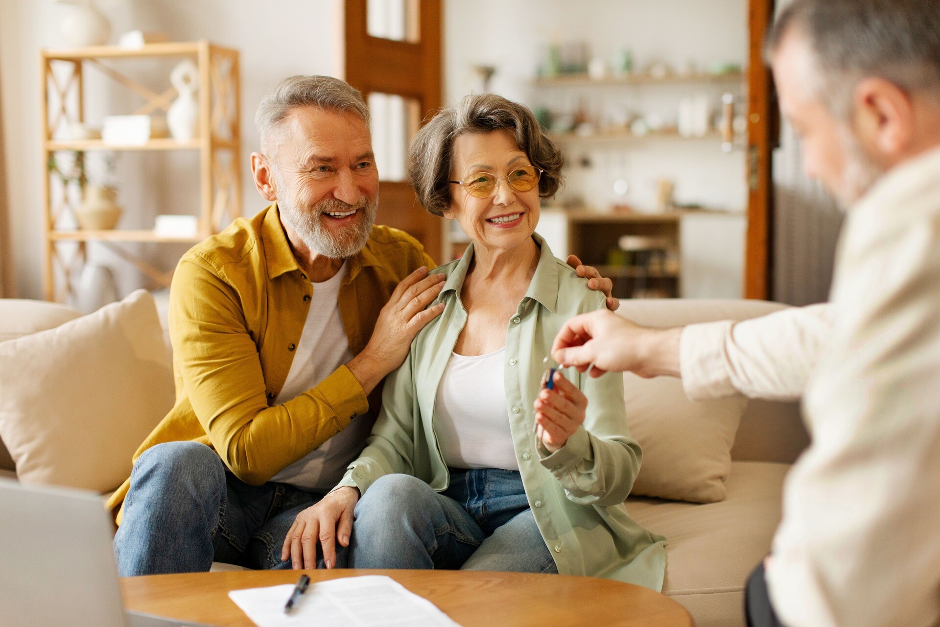 Seniorenpaar nimmt Schlüssel entgegen.
