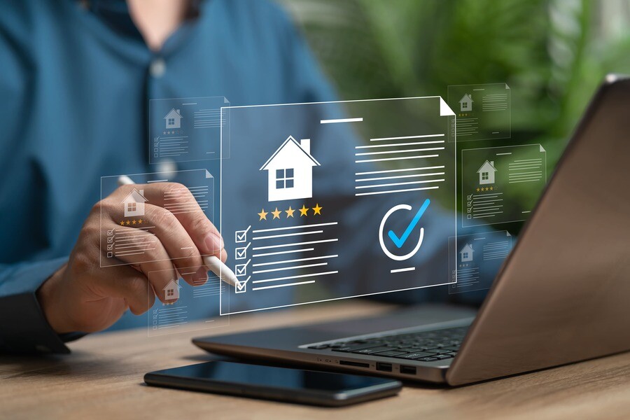 Laptop mit Immobiliensymbolen und Checklisten auf dem Bildschirm.