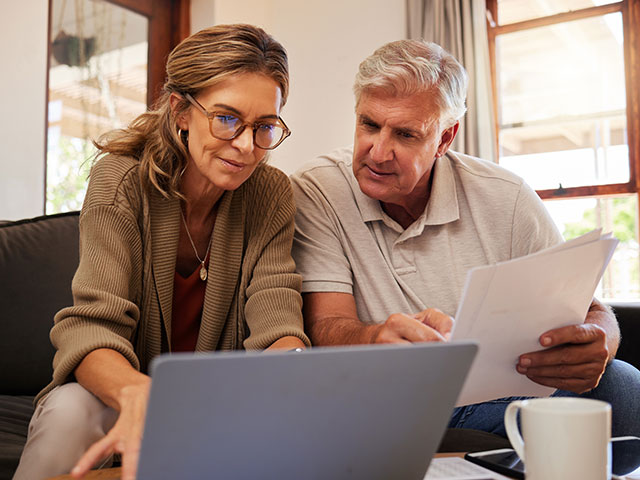 Älteres Ehepaar informiert sich am Laptop zum Privatverkauf