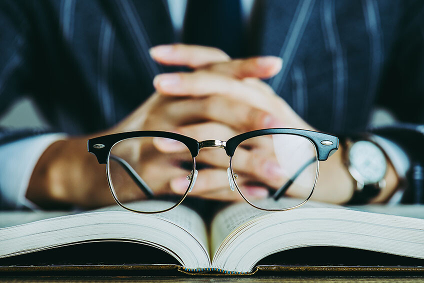Brille liegt auf offenem Buch
