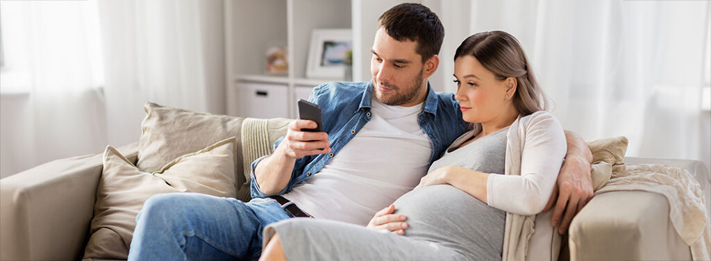 Junges Paar ist schwanger und plant Immobilienkauf für den Familienzuwachs