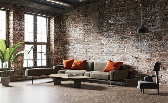 Ein Wohnzimmer im industriellen Stil mit Backsteinwand und Couchmöbeln