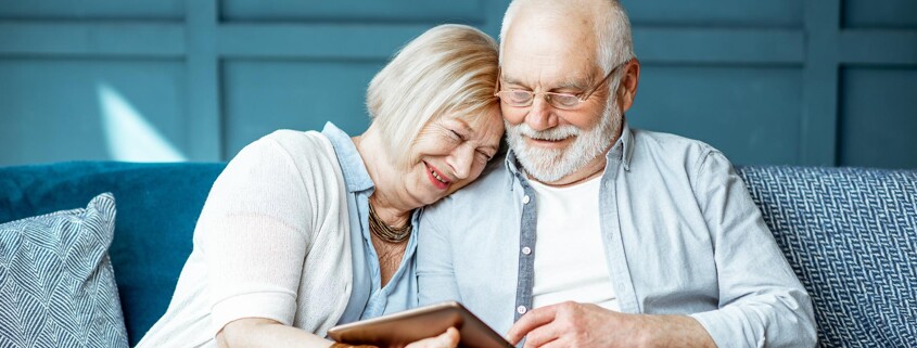 Seniorenpaar auf der Couch mit Tablet