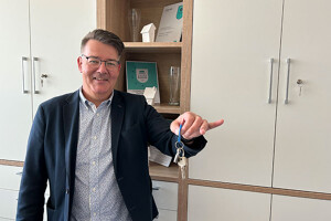 Dirk Schlösser mit Schlüssel in seinem Büro: Ihr guter & lokaler Makler