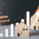 Grafik mit Balken und Holzhäusern als Symbol für die Marktentwicklung
