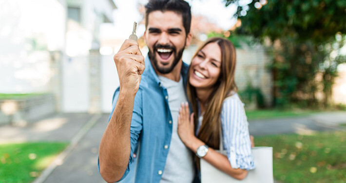 Junges Paar freut sich nach dem alle Schritte des Immobilienkaufs abgeschlossen sind