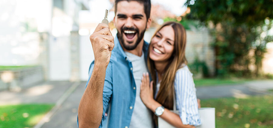 Junges Paar freut sich nach dem alle Schritte des Immobilienkaufs abgeschlossen sind