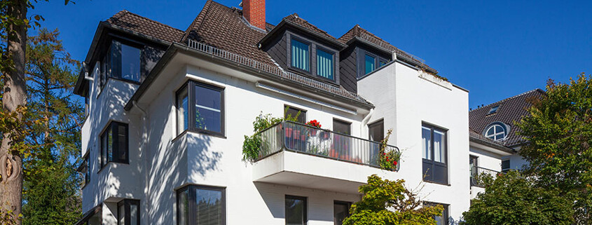 Blick auf ein Mehrfamilienhaus mit Balkonen, dass als Kapitalanlage genutzt wird