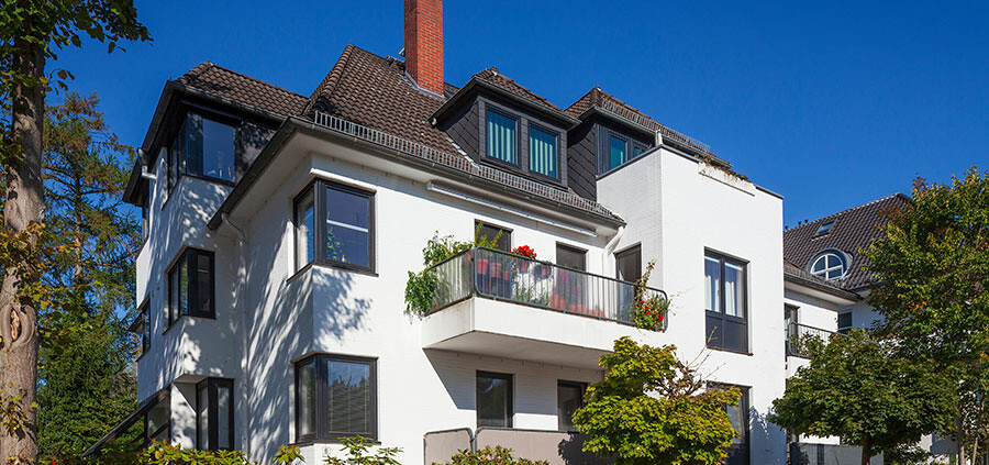 Blick auf ein Mehrfamilienhaus mit Balkonen, dass als Kapitalanlage genutzt wird