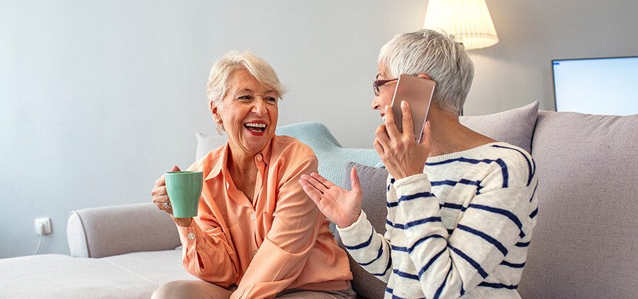 Zwei ältere Damen sitzen auf einer Couch in einer altersgerechten Neubauwohnung