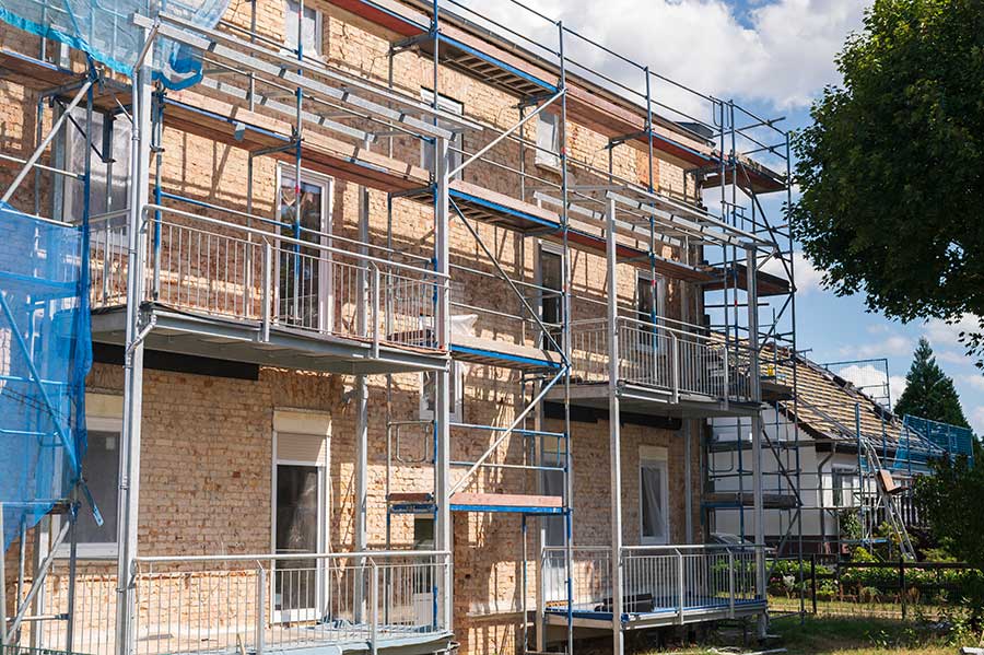 Gerüst an einem Mehrfamilienhaus zur energetischen Sanierung der Fassade