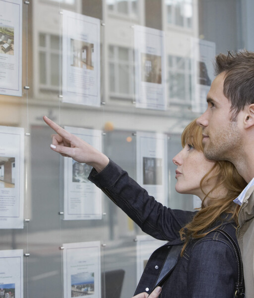 Paar vor Immobilienschaufenster