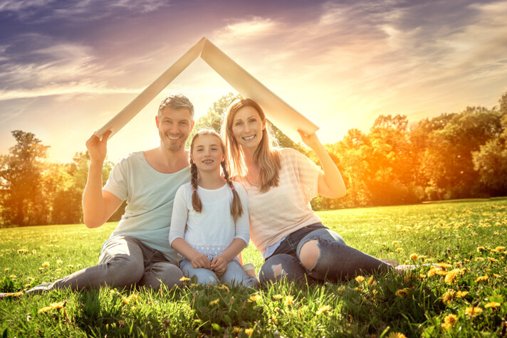 Familie auf Wiese mit Pappdach