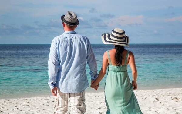 Ein Ehepaar spaziert am Strand entland