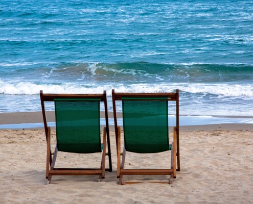 Zwei Liegestühle am Strand