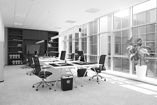 Modernes Büro mit Arbeitsplätzen, Computern und großem Bildschirm an der Wand